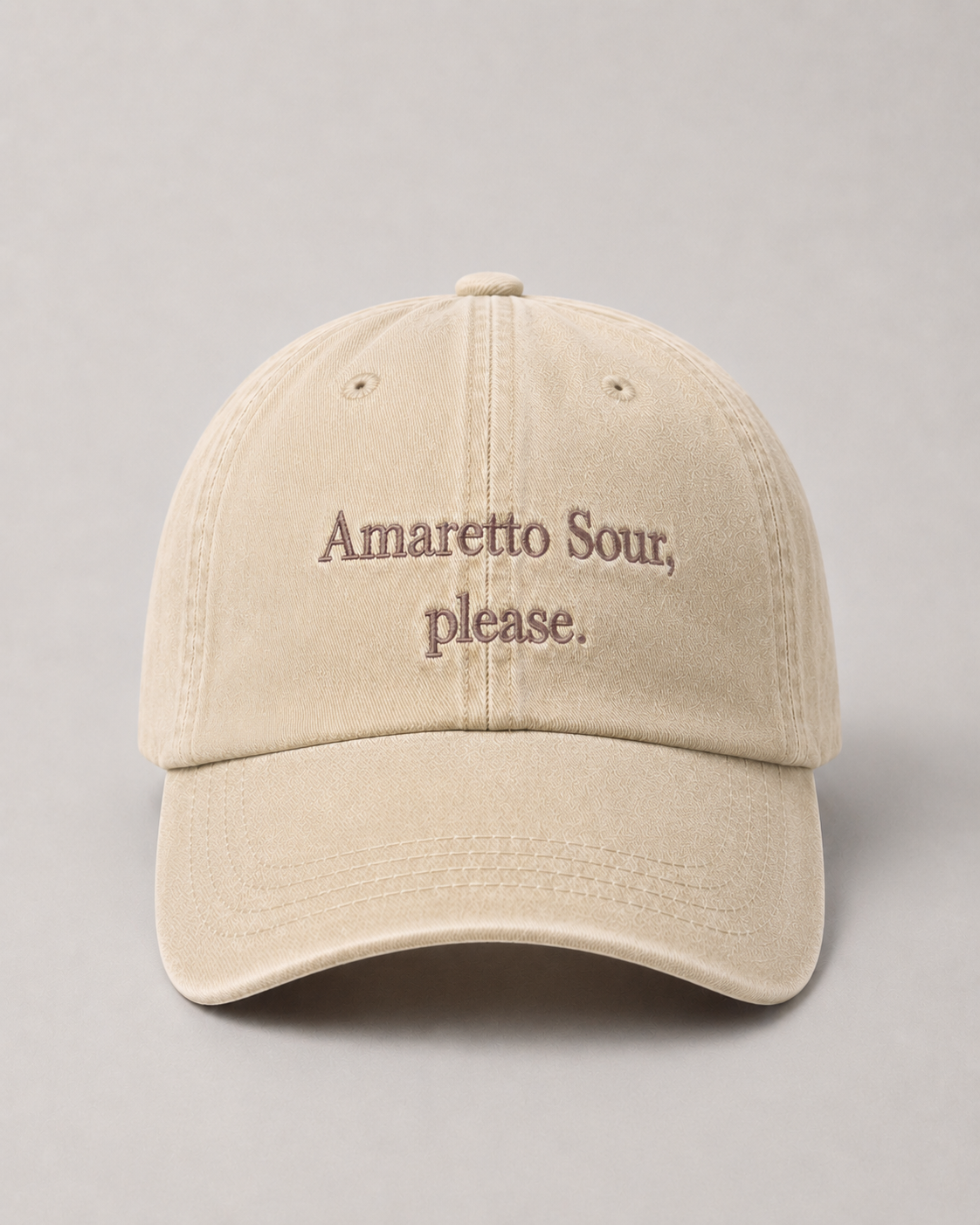 Beige cap with 'Amaretto Sour, please.' text on a gray background