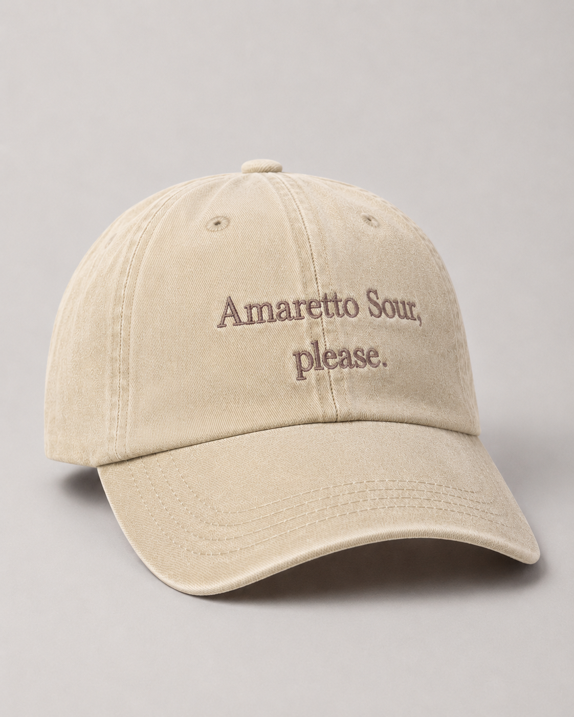 Beige cap with 'Amaretto Sour, Please.' text on a gray background