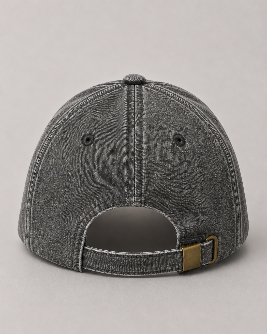 Gray denim cap with a brown leather strap on a light gray background