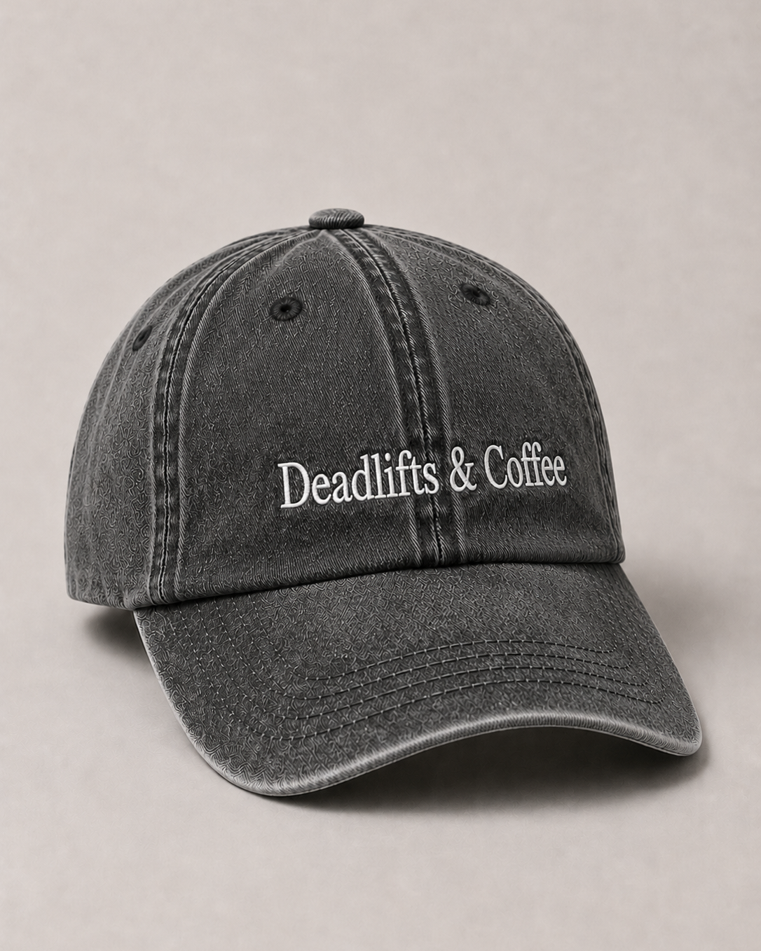 Gray cap with 'Deadlifts & Coffee' text on a beige background