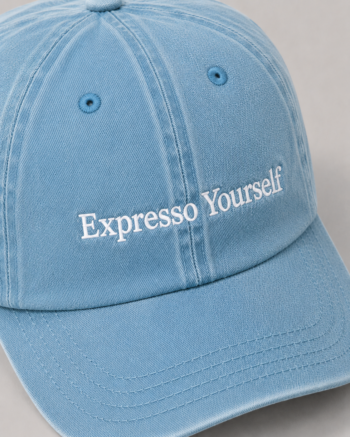 Light blue cap with 'Expresso Yourself' text on a gray background