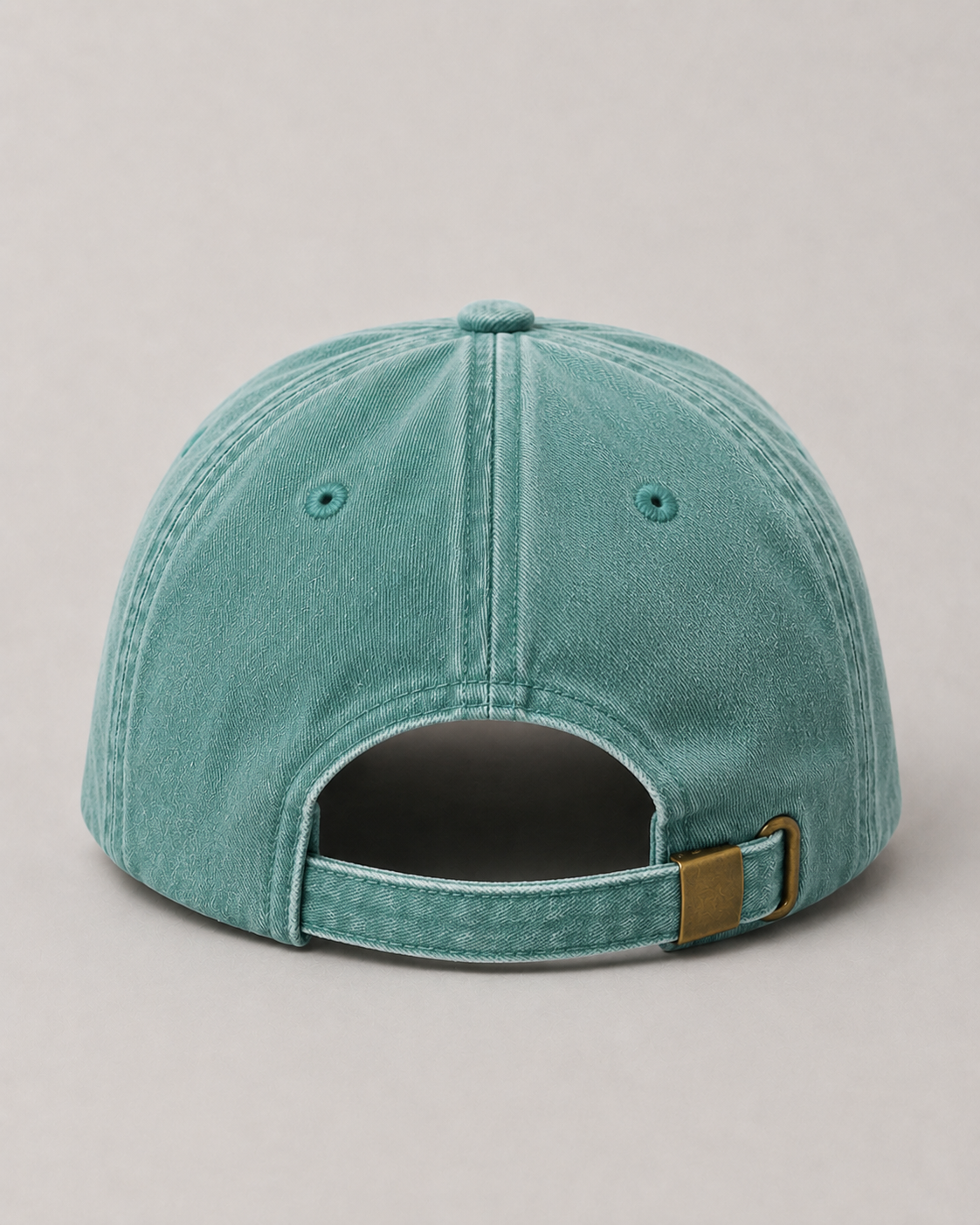 Teal baseball cap with a brown patch on a light gray background
