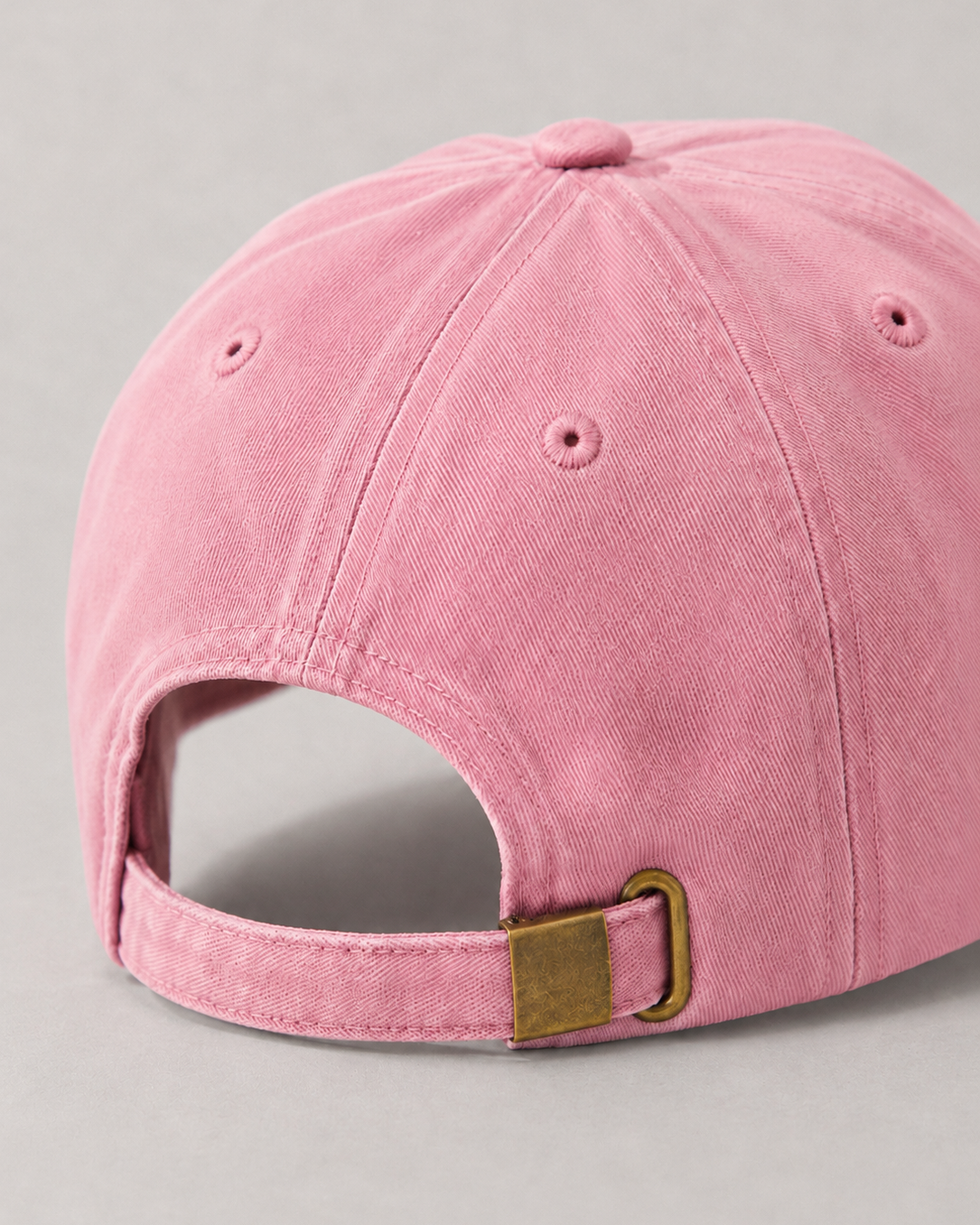 Pink baseball detail back cap cap with a brown buckle on a gray background