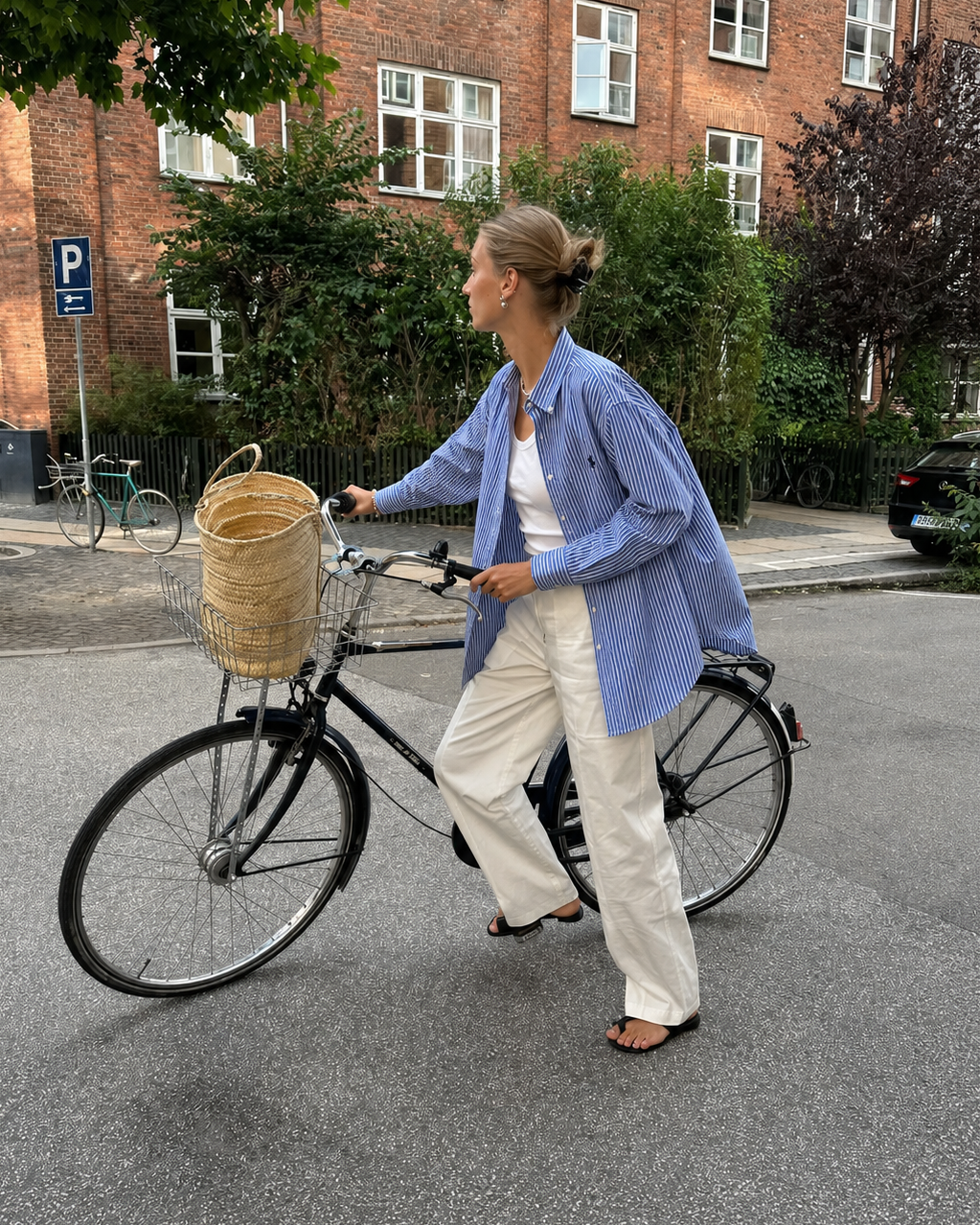 Woman with a bicycle on a street in an urban setting