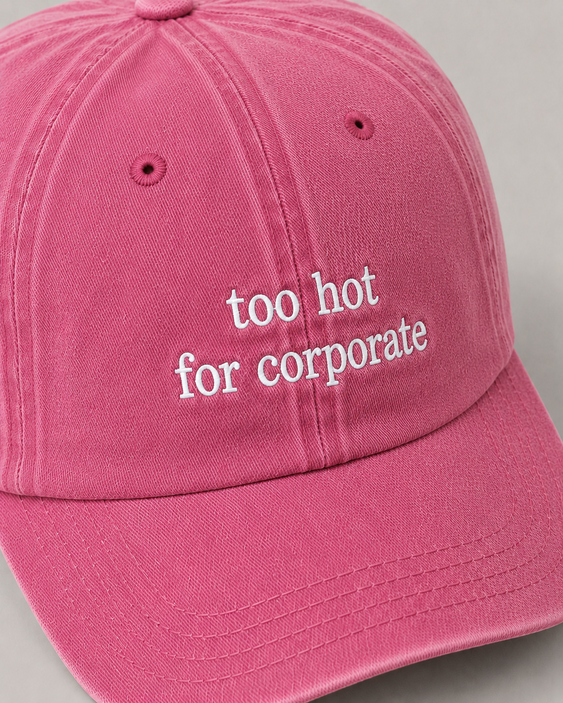 Pink cap with 'too hot for corporate' text on a gray background