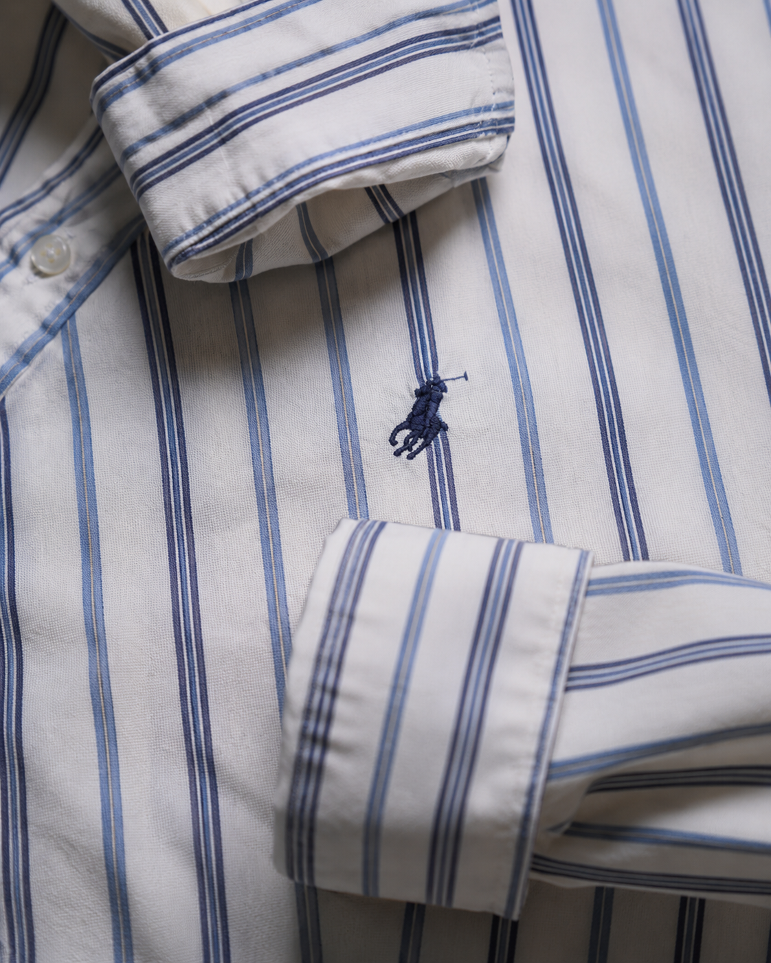 Close-up of a Navy embroidered Ralph Lauren pony logo on navy blue white striped shirt
